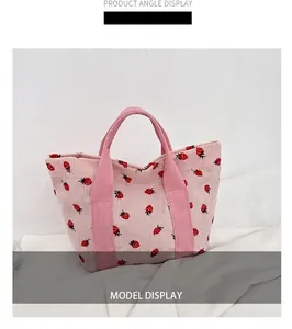 Close-up detail of the pink corduroy tote bag featuring a cute strawberry pattern print