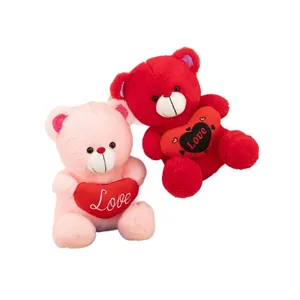 Adorable pair of pink and red plush teddy bears holding red hearts with Love embroidery