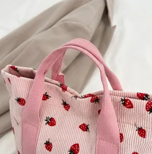 Close-up van de roze corduroy stof en handvatten van de shopper met aardbeienprint