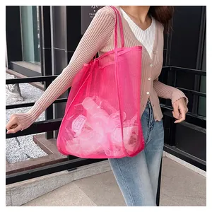 Detailed view of a bright pink large capacity mesh beach tote bag for travel storage