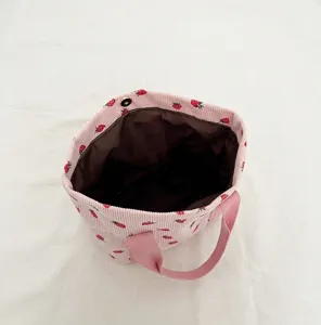 Gedetailleerd zicht op de bruine voering van de roze corduroy tas met aardbeien