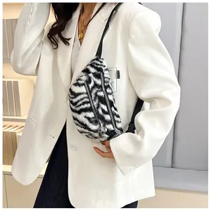 Close-up detail of a stylish zebra print plush chest bag styled with a white blazer outfit.