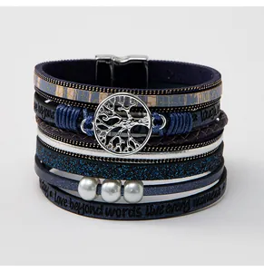 Detailansicht eines mehrlagigen Lederarmbands mit Lebensbaum-Anhänger und Magnetverschluss.
