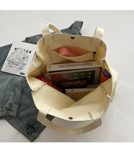 Close-up of the spacious interior of a cream canvas tote bag showing large capacity.