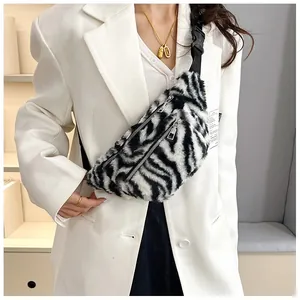 Detail view of plush zebra-print crossbody chest bag styled on a white casual blazer