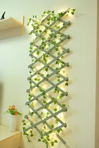Detailansicht der LED-Grünblatt-Rebenleuchten an einem hölzernen Wandgitter