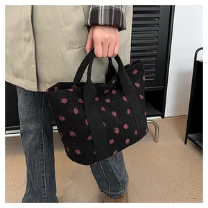 Close-up of a corduroy tote bag featuring pink strawberry prints for women