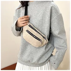Detail view of a cream fuzzy sherpa belt bag worn as a stylish crossbody chest pack