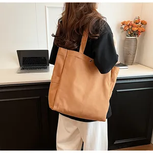 Durable brown canvas tote bag for women shown in a stylish lifestyle office setting