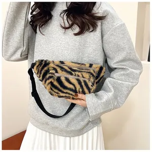 Macro view showing the soft tiger-patterned plush texture and dual metal zippers on fanny pack