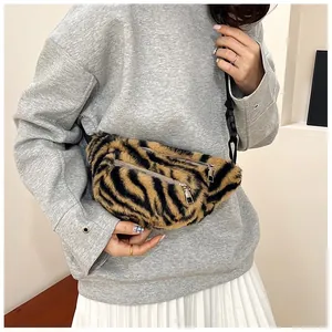 Detailed view of a plush fanny pack with tiger stripe pattern and zippers on a model