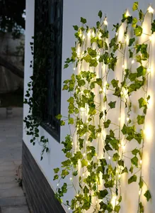 Detailansicht von warmweißen LED-Lichterketten mit künstlichen grünen Efeuranken