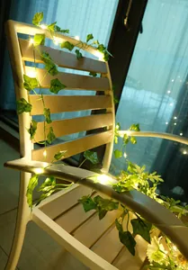 Warmweiße LED-Efeulichterkette um einen Stuhl gewickelt für die Gartendekoration