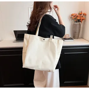 Modern minimalist beige canvas tote bag for women shown on model in an office setting