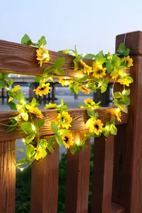Detail von Solar-Sonnenblumen-LED-Lichterketten an einem hölzernen Außengeländer.