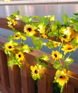 Warme LED Sonnenblumen-Lichterkette über einem hölzernen Gartenland am Abend.