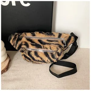 Detail shot of a plush tiger-striped fanny pack with dual silver zippers and black strap.