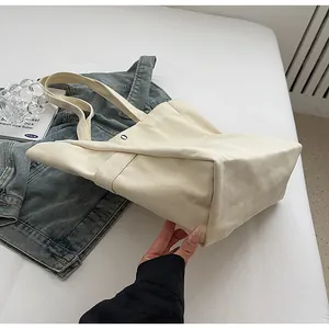 Detail view showing the wide bottom and sturdy canvas material of the tote bag
