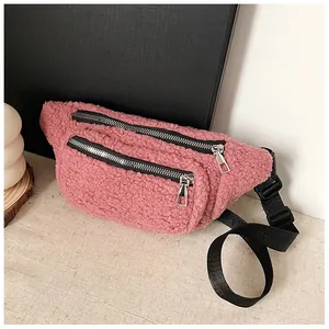 Detailed view of the pink sherpa fleece waist bag with dual silver zippers
