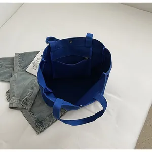 Interior view of blue canvas tote bag showing zipper pocket and spacious design