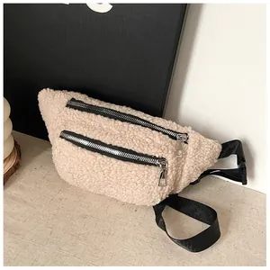 Macro view of a beige plush sherpa chest bag featuring silver zippers and black strap.
