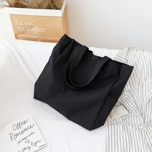Minimalist black canvas tote bag for women shown in an aesthetic lifestyle scene