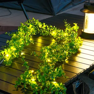 Detailansicht der solarbetriebenen LED-Grünblatt-Lichterkette auf einem Tisch im Freien.