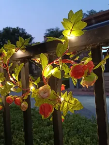 Warmweiße LED-Rosenrankenlichter wunderschön um einen Gartenzaun bei Nacht gewickelt