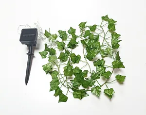 Detailansicht von Solarpanel und künstlicher Efeublatt-Lichterkette für den Garten