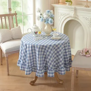 Close-up of blue and white gingham round tablecloth featuring elegant ruffled edges.