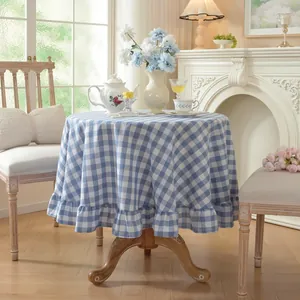 Blue and white checkered round tablecloth with elegant ruffled edge detail in a room