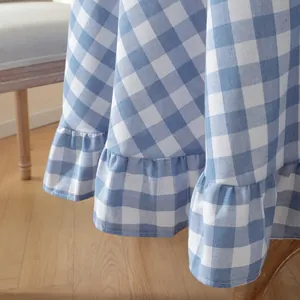 Detailed macro shot of blue checkered tablecloth featuring stylish ruffled edge finish