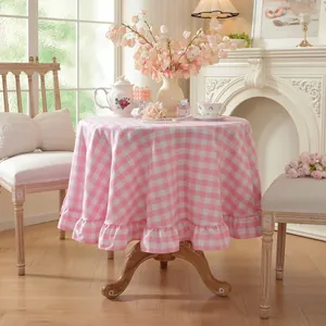 Detail view of pink gingham round tablecloth featuring elegant ruffled lotus leaf edge design