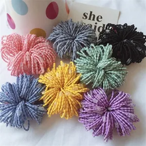 Detail view of colorful 2.5cm mesh pom-poms for DIY baby hair clips and crafts.