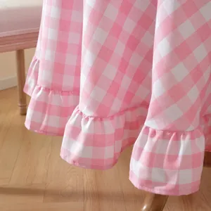 Close-up detail of a pink and white checkered tablecloth with a ruffled lotus edge