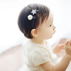 Cute baby girl wearing handmade white mesh ball and silver star hair clips.
