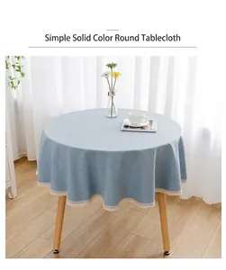Hellblaue runde Tischdecke mit weißer Spitzenkante in einem hellen Wohnambiente