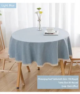 Detailansicht der hellblauen runden Tischdecke mit eleganter Spitze auf Holztisch