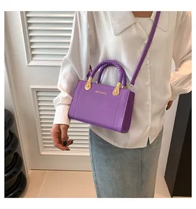 Stylish purple textured leather handbag with braided handles and gold-tone accents