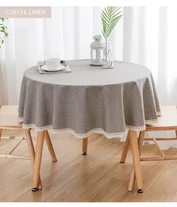 Detailaufnahme der runden Tischdecke aus Kaffeelinnen mit elegantem weißem Spitzenrand