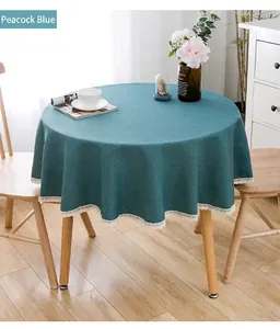 Pfauenblaue runde Tischdecke mit weißer Spitzenkante in gemütlicher Esszimmer-Szene.