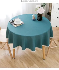 Nahaufnahme einer petrolfarbenen runden Tischdecke mit elegantem weißem Spitzenrand