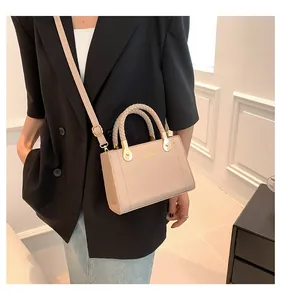 Elegant beige handbag featuring a unique woven handle and gold-tone logo detail.