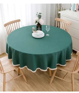 Blaugrüne runde Tischdecke mit weißem Spitzenrand in gemütlicher häuslicher Umgebung.