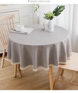 Detail einer grauen runden Tischdecke mit elegantem Spitzenrand im modernen Esszimmer