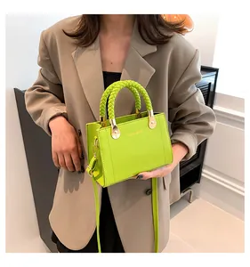 Close-up of lime green handbag with unique woven handles and elegant gold hardware