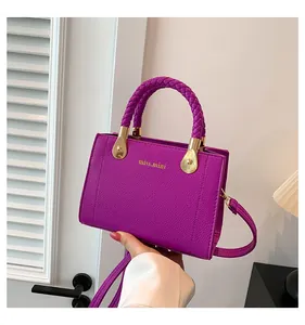 Detailed view of a purple handbag with unique braided handles and gold-tone accents.
