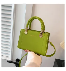 Detailed view of stylish green leather handbag with woven handle and gold accents