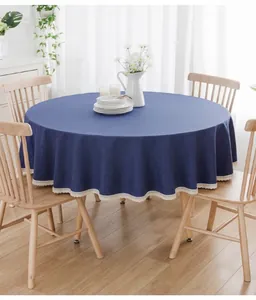 Detailansicht der dunkelblauen runden Tischdecke mit weißer Spitze auf Esstisch