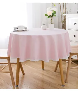 Rosa runde Tischdecke mit zarter weißer Spitze in heller Wohnumgebung